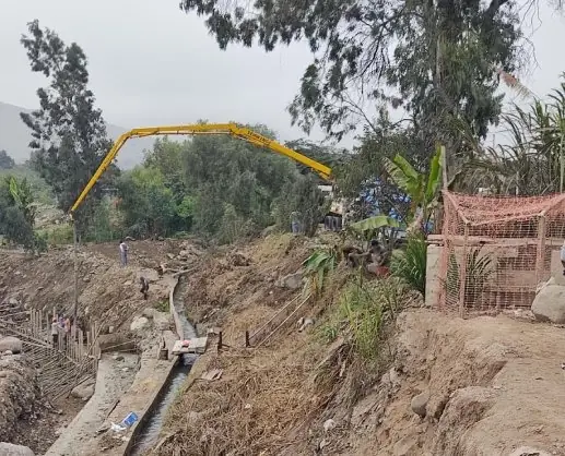 Bomba pluma vaciando concreto en un canal