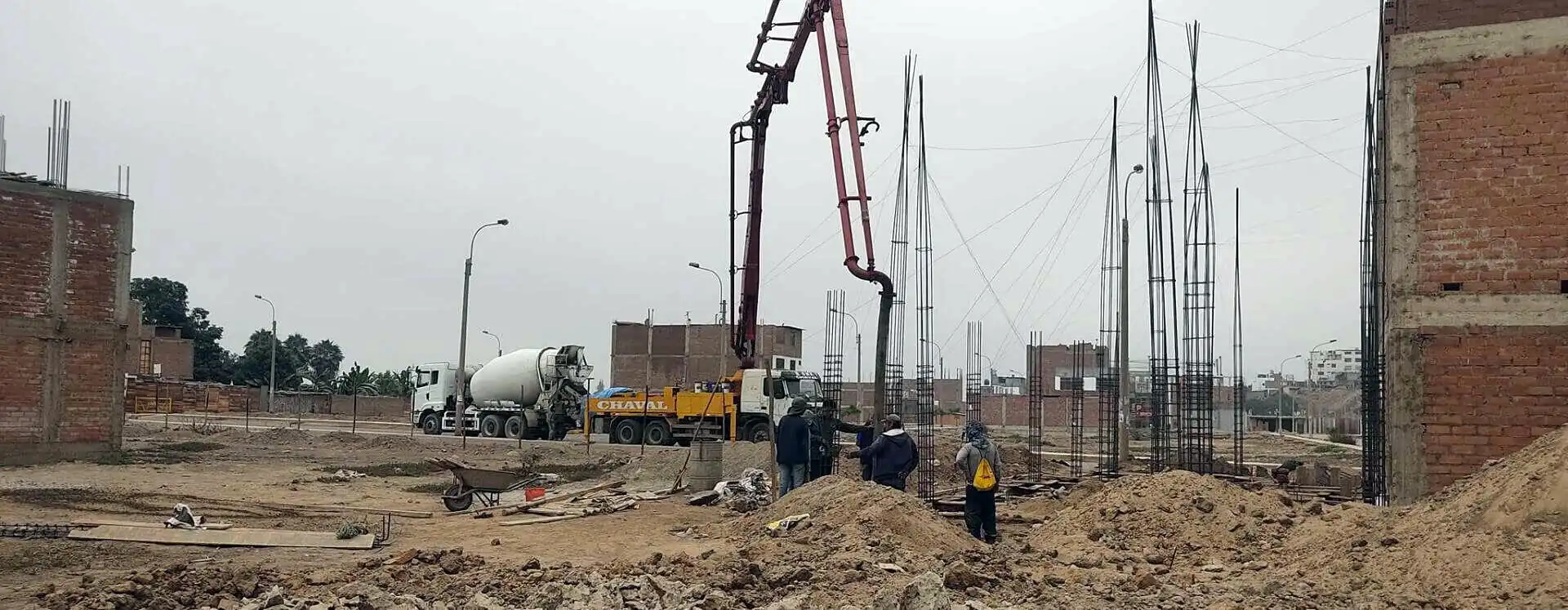 Bomba pluma y mixer de concreto vaciando columnas en una obra de Lima
