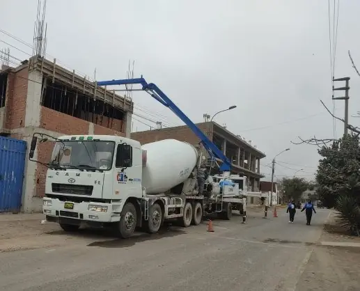 Mixer y bomba pluma azul vaciando en una calle