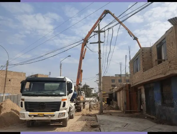 Mixer de concreto y bomba pluma estacionados en una calle durante un vaciado