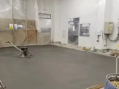 Piso industrial de concreto recién alisado con allanadora mecánica