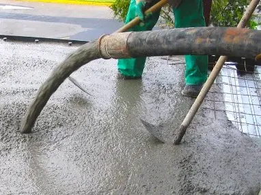 Manguera de bomba vaciando concreto sobre una losa con malla de acero